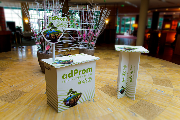 Counter adProm mit Kopfschild aus 16mm Wabenplatte. Dazu passender Stehtisch aus 16mm Wabenplatte.