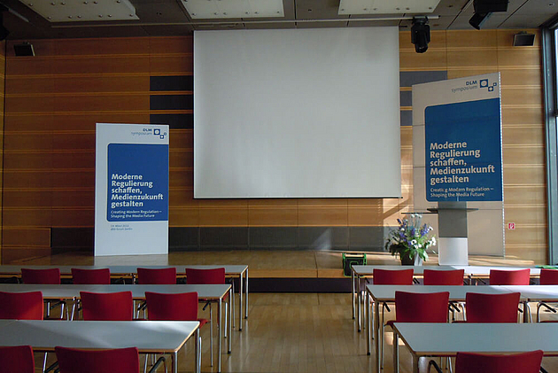 DLM-Symposium Medienanstalten.Bühnenrückwände, Rednerpultschilder.